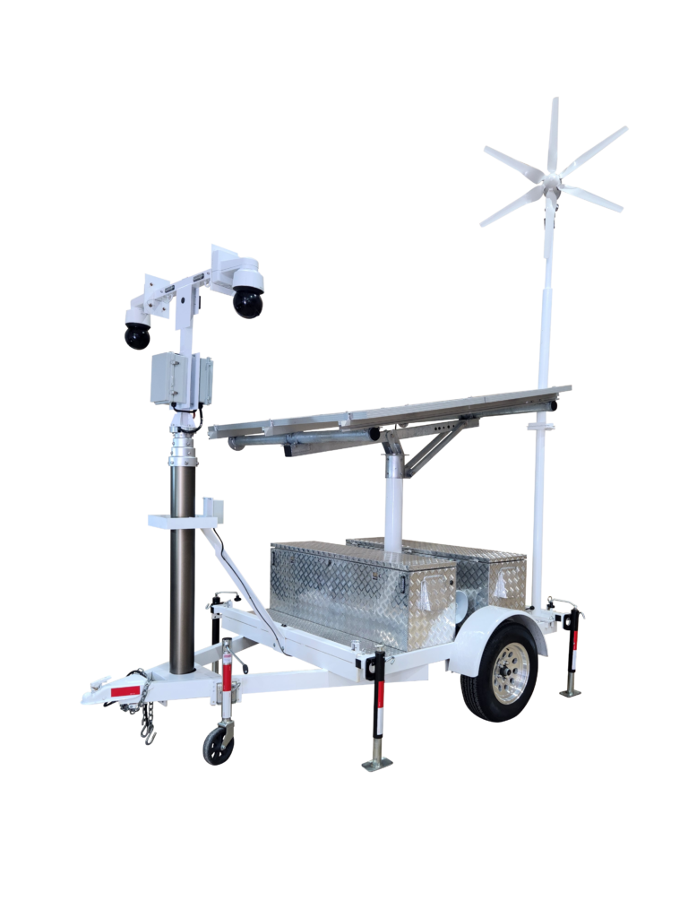 A mobile surveillance trailer powered by wind and solar energy. The trailer is equipped with solar panels and a wind turbine, with cameras and lights visible on top of the mast.
